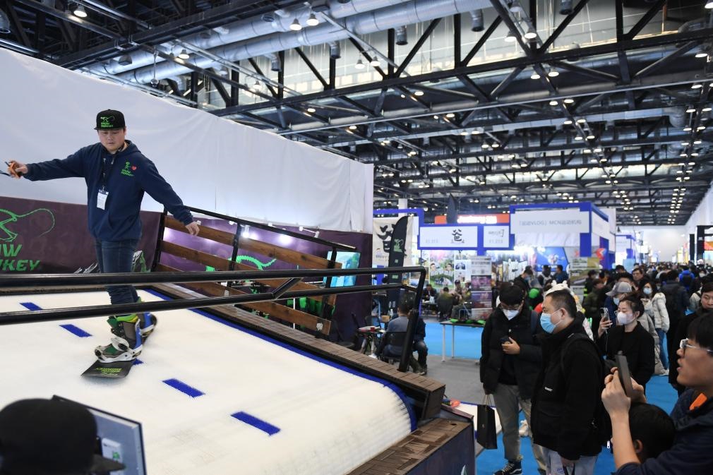 2023年2月11日，參觀者在展會上了解一款模擬滑雪設(shè)備。當日，2023亞洲運動用品與時尚展在國家會議中心拉開帷幕。新華社記者 張晨霖 攝