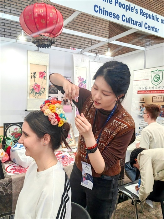 展覽正值羅馬尼亞迎春花節(jié)，國際中文教師志愿者潘婧穎向游客們介紹了國家非物質(zhì)文化遺產(chǎn)——福建泉州的簪花文化。布加勒斯特大學(xué)孔子學(xué)院供圖。