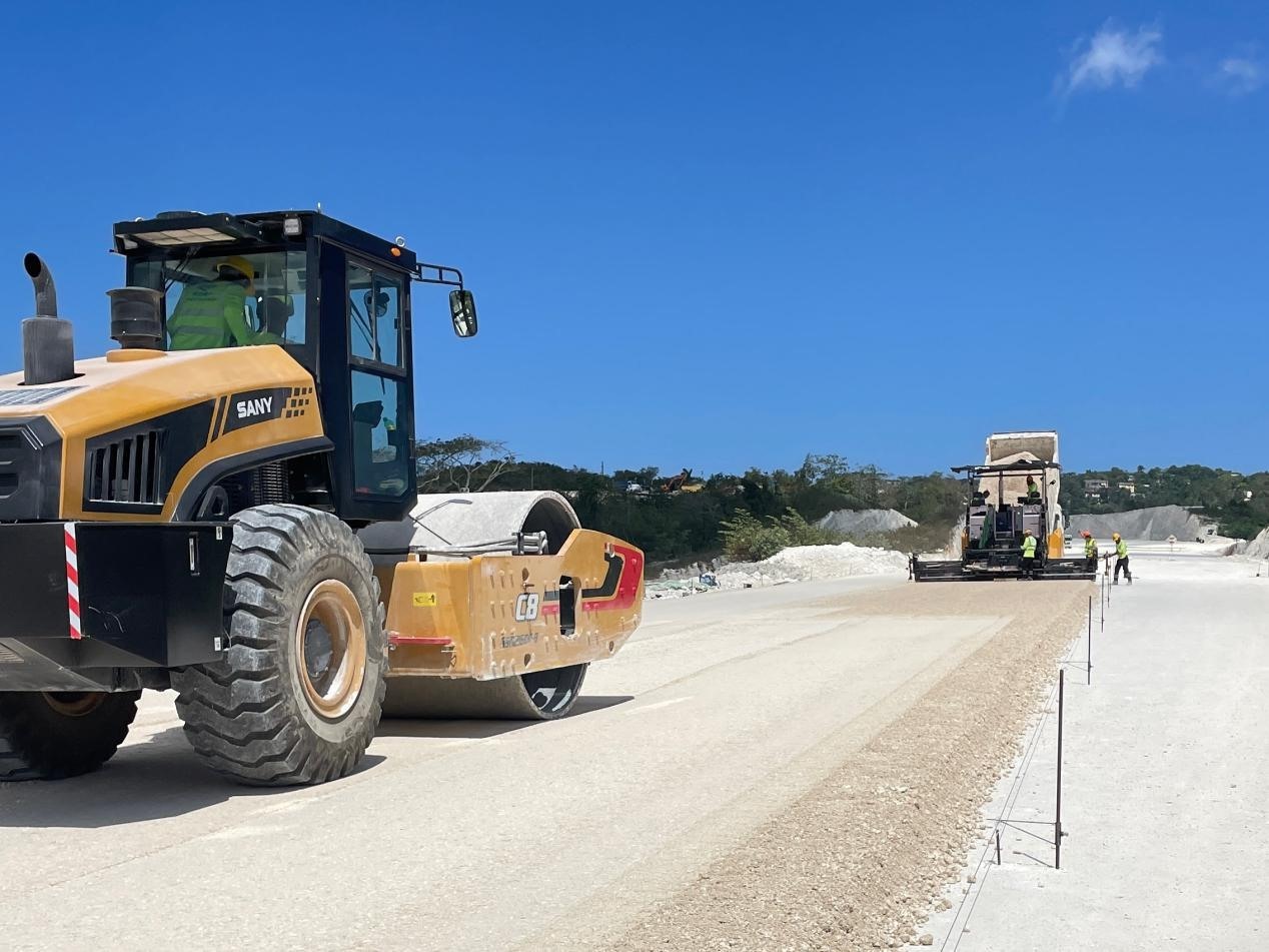圖為中企承建的牙買加蒙特哥貝繞城路項(xiàng)目基層試驗(yàn)段正在進(jìn)行攤鋪和碾壓施工，相關(guān)施工工作已于日前順利完成。中國(guó)港灣美洲區(qū)域公司供圖