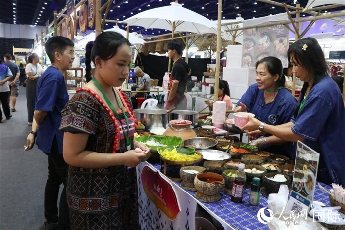 游客在攤位前購買特色美食。朱瀟逸攝