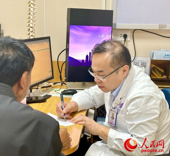 路桂軍接診時為患者寫下用藥提示。人民網(wǎng)記者 金慧慧攝