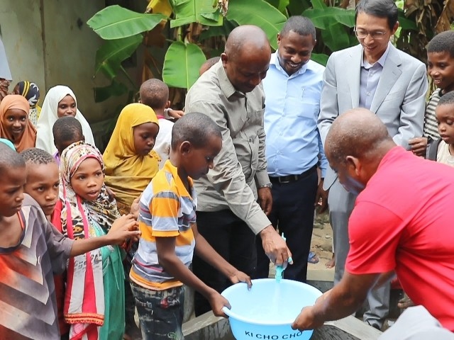 在日前舉行的安全供水工程揭牌儀式上，當(dāng)?shù)匦∨笥言诠┧c(diǎn)接水。 施亮攝