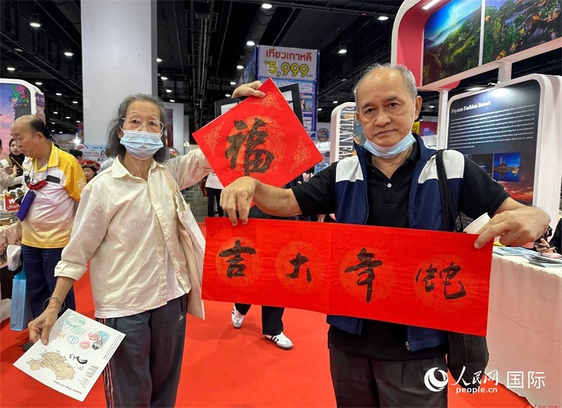 2025蛇年春節(jié)，泰國市民展示他們領(lǐng)到的華人手寫春聯(lián)。人民網(wǎng)記者 簡承淵攝