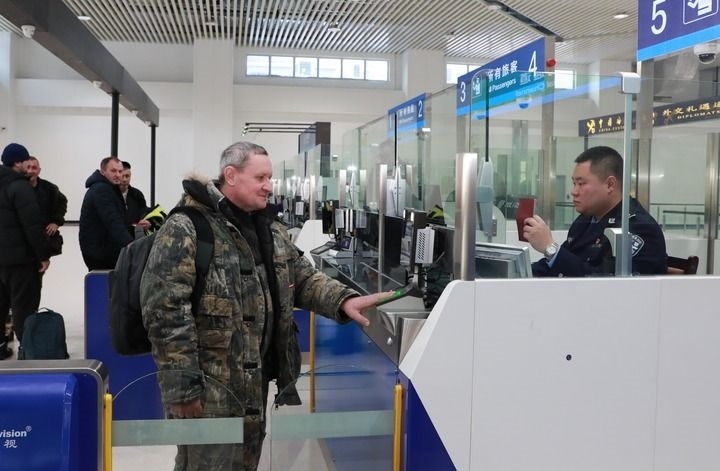 2024年12月10日，在黑河公路口岸旅檢大廳，黑河出入境邊防檢查站民警為首班次客車入境旅客辦理邊檢通關(guān)手續(xù)。當(dāng)日，中國黑河公路口岸—俄羅斯卡尼庫爾干公路口岸旅客運(yùn)輸正式開通。新華社發(fā)（劉松攝）