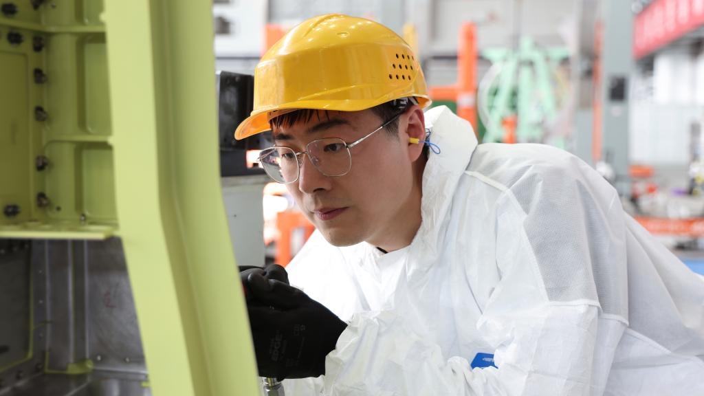 在中國(guó)航空工業(yè)集團(tuán)成飛車間內(nèi)，飛機(jī)鉚裝鉗工首席操作技師馮攀龍正在工作。（新華社發(fā)）