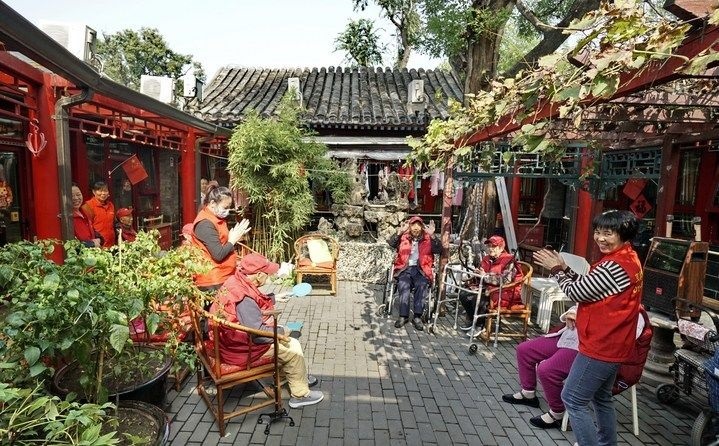 2024年10月12日，鐘樓灣胡同的老年人在社區(qū)內(nèi)的四合院養(yǎng)老驛站休閑。2017年起，北京市先后開展了兩輪背街小巷環(huán)境整治提升行動，完整保留了中軸線生活建筑群的歷史信息，并根據(jù)居民的生活和居住方式進行適配化的更新和改造，極大地改善了生活環(huán)境。2023年鐘樓灣胡同被評為“北京最美街巷”。