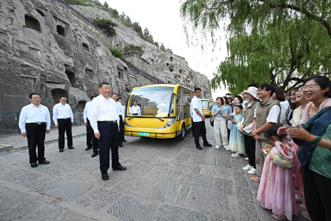 5月19日，習近平在洛陽龍門石窟考察時，同游客親切交流。