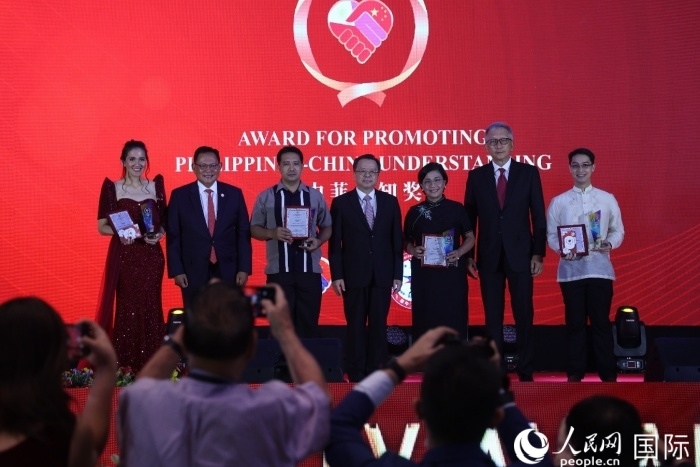 黃溪連大使和菲中了解協(xié)會主席與榮獲“友誼獎”的獲獎者合影留念。人民網記者 樊帆攝